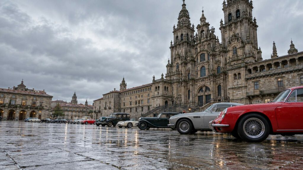 Coches clásicos aparcados en la Praza do Obradoiro frente a la catedral de Santiago en un día lluvioso